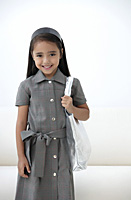 A young girl dressed in school uniform with a bag - Asia Images Group