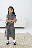 A young girl dressed in school uniform crosses her arms - Asia Images Group