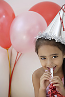A young girl at a party with balloons - Asia Images Group