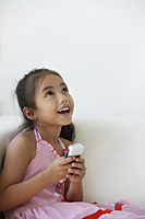 A young girl plays with a cellphone - Asia Images Group