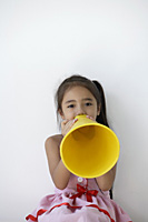 A young girl plays with a yellow cone - Asia Images Group