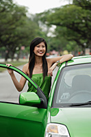 A young woman in a green dress with a green car - Asia Images Group