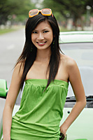 A young woman in a green dress with a green car - Asia Images Group