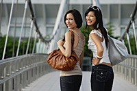 Two friends walk across a bridge together - Asia Images Group