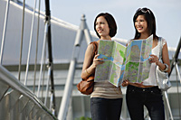 Two friends check a map together - Asia Images Group