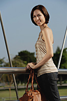 A woman stands on a bridge - Asia Images Group