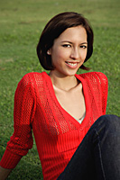 A woman relaxes on grass - Asia Images Group