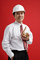 A man wearing a shirt and tie with a hardhat - Asia Images Group