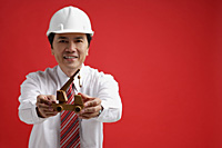 A man wearing a shirt and tie with a hardhat - Asia Images Group