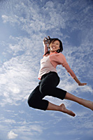 A young woman jumps for joy - Asia Images Group