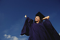 A young woman dressed in her graduation gown - Asia Images Group