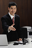 A businessman extends his hand to shake hands - Asia Images Group
