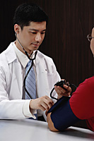 A doctor examines a patient - Asia Images Group