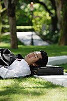 A man lies down and has a rest in the park - Asia Images Group