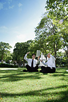 Two men get excited as they read the newspaper in the park - Asia Images Group