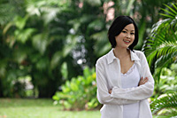 A woman in a garden smiles at the camera - Asia Images Group
