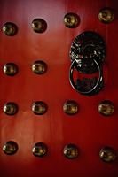 Brass lion head door knocker at temple - Asia Images Group
