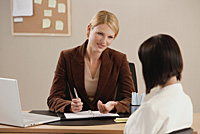 Two woman talk together at work - Asia Images Group