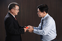 One man gives another a business card - Asia Images Group