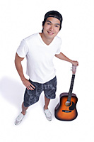 A man holds a guitar and smiles at the camera - Asia Images Group