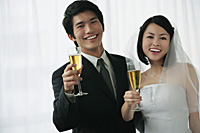 A newlywed couple smile at the camera - Asia Images Group