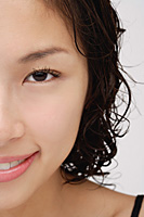 Cropped face of a woman smiling at the camera - Asia Images Group
