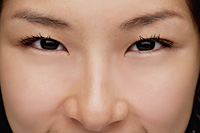 A close-up of a young woman looking at the camera - Asia Images Group