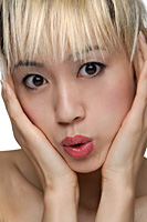 A young woman with dyed blonde hair looks at the camera - Asia Images Group