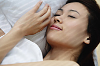 A woman asleep in bed - Asia Images Group