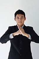 A man in a business suit makes a threatening gesture - Asia Images Group
