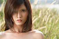 Woman in long grass looking at camera - Asia Images Group