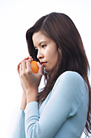 Woman holding orange - Asia Images Group