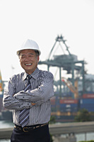 Man with helmet and arms crossed, looking at camera - Asia Images Group