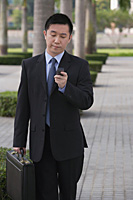 Businessman holding mobile phone - Asia Images Group