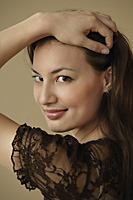 Portrait of young woman smiling over shoulder at camera - Asia Images Group