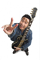 Man holding guitar, giving peace sign and smiling at camera - Asia Images Group