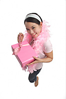 Young woman holding present and smiling at camera - Asia Images Group