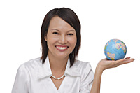 Woman holding globe and smiling at camera - Asia Images Group