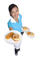 Waitress smiling at camera, serving breakfast - Asia Images Group
