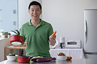 Man cooking and smiling at camera - Asia Images Group