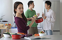 Woman cooking while men talk - Asia Images Group