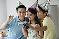 Friends celebrating and videotaping it - Asia Images Group