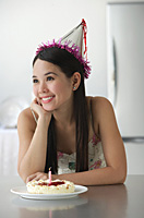Young woman with cake smiling - Asia Images Group