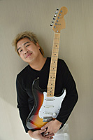 Man with guitar smiling at camera - Asia Images Group