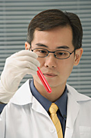Scientist examining test tube - Asia Images Group