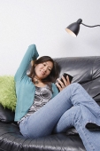 Young woman sitting in couch looking at organizer - Asia Images Group