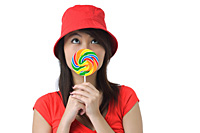 Young woman with lollipop looking up - Asia Images Group
