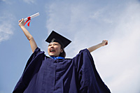 University student in graduation robe cheering - Asia Images Group