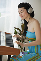Young woman playing keyboard - Asia Images Group