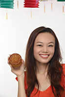 Young woman with Chinese lantern smiling at camera - Asia Images Group